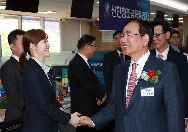 Shinhan Financial Group chairman Han Dong-woo shakes hands with officials at Shinhan’s Creative Financial Plaza in April. (Shinhan Financial Group)