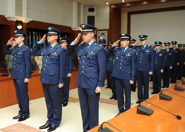 Air Force interpreter officers salute at a ceremony in March at the Air Force’s Operations Command in Osan Air Base, Gyeonggi Province, marking their completion of training. (Air Force)