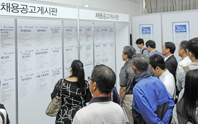 Korean job seekers look at job postings. (Yonhap)