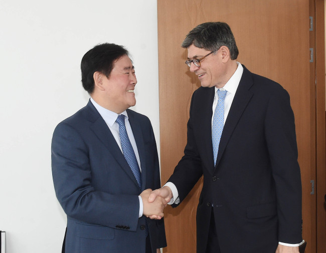 Finance Minister Choi Kyung-hwan (left) shakes hands with his U.S. counterpart Jacob Lew prior to their talks on the sidelines of the 2015 IMF/World Bank Annual Meetings in Lima, Peru, on Saturday. (Yonhap)