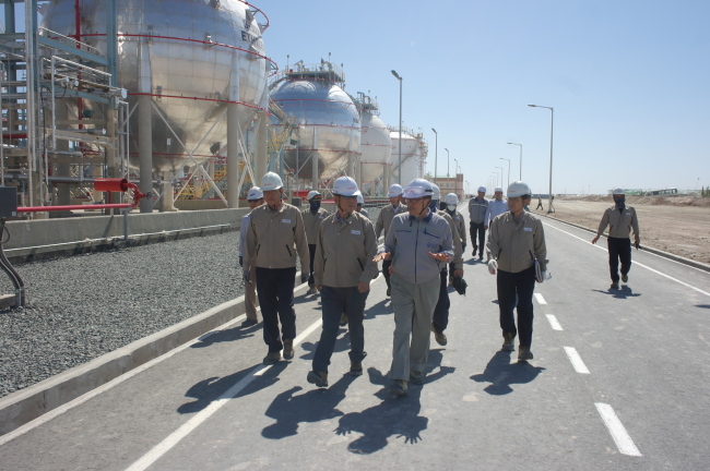 Lotte Chemical CEO Huh Soo-young (second from left) and other company officials examine the newly constructed gas and chemicals complex in Surgil, Uzbekistan, which began operations this month. (Lotte Chemical)