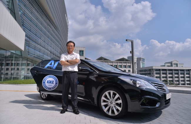 Sunwoo Myoungho, professor of automotive engineering at Hanyang University, poses next to a fourth generation self-driving car developed by the Automotive Control and Electronics Laboratory at the university’s Seoul campus on Sept. 3. (Lee Sang-sub/The Korea Herald)