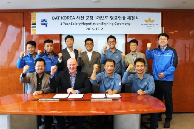 BAT Korea CEO Guy Meldrum (front row, second from left) poses with union leaders from its Sacheon factory after signing a wage pact for the next three years at the firm’s Seoul headquarters Wednesday. (BAT Korea)