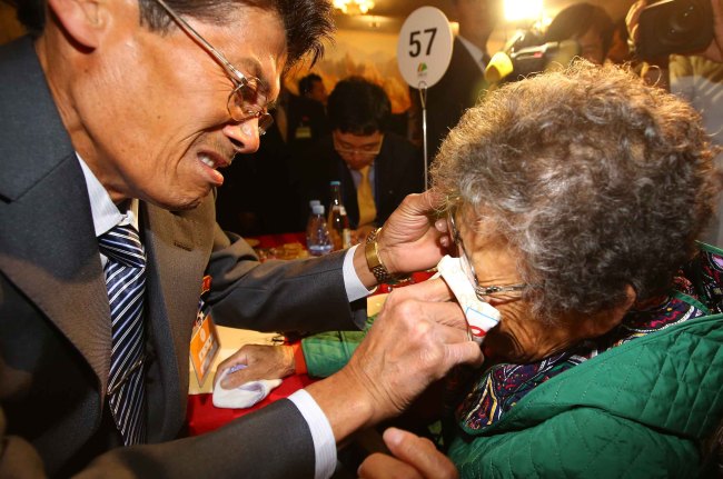 Jeong Geon-mok (left) from North Korea wipes the tears from his South Korean mother Lee Bok-sun’s face during the second round of family reunions at Geumgangsan Hotel in North Korea on Saturday. (Yonhap)