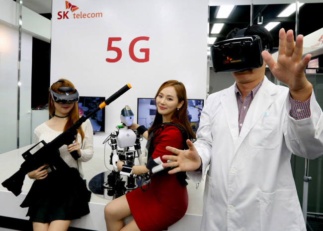 Models pose with virtual reality products at SK Telecom`s 5G Playground, an R&D cetner, in Bundang, Gyeonggi Province on Thursday. SKT