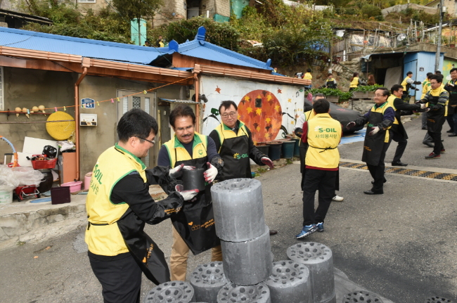 HEAT FOR LOW-INCOME HOUSEHOLDS — S-Oil CEO Nasser Al-Mahasher (second from left) and company officials deliver 50,000 coal briquettes to low-income households and senior citizens living alone in Seoul, Thursday. Since 2008, the oil refiner has been delivering coal to underprivileged citizens in the winter as part of its “Coal Briquette of Love Program.” (S-Oil)