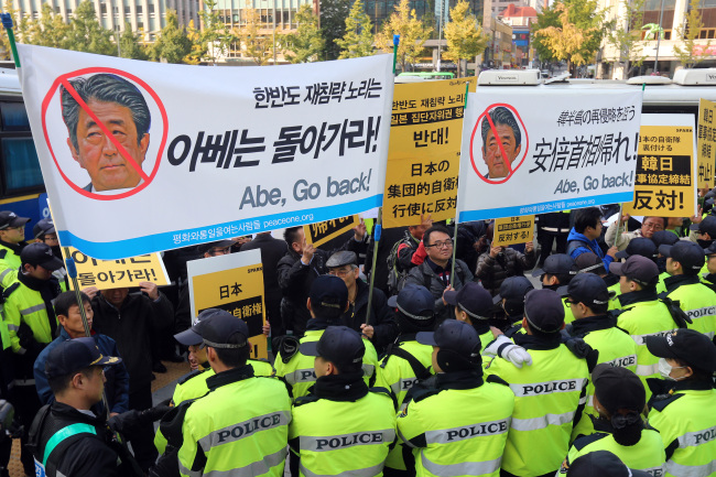 Activists protesting the visit by Japanese Prime Minister Shinzo Abe are blocked by police in downtown Seoul on Monday. (Yonhap)