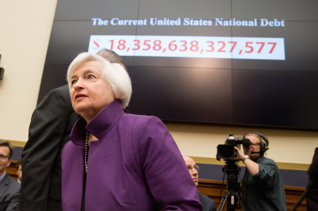 Federal Reserve Chair Janet Yellen passes a national debt banner as she arrives on Capitol Hill in Washington on Nov. 4 to testify before the House Financial Services Committee hearing on banking supervision and regulation. (AP)