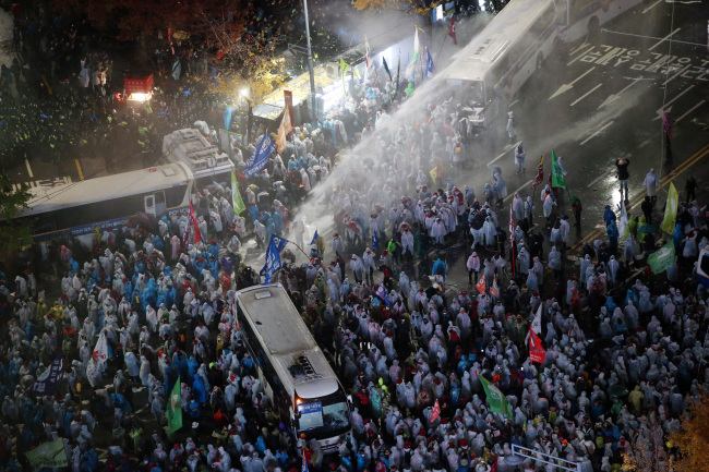 Riot police fire water cannons at protesters during a rally in Gwanghwamun Square, Seoul, Saturday. (Yonhap)