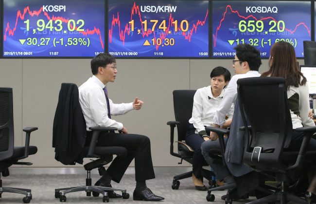 Currency dealers talk at a trading room at KEB Hana Bank in Seoul, Monday, when the Korean won and equities lost sharply. (Yonhap)