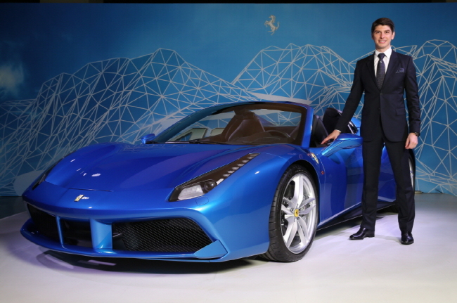 Ferrari Japan managing director Reno De Paoli, who is also in charge of the Korean market, poses next to the new 488 Spider, the Italian supercar’s latest and most powerful Spider, featuring the patented retractable hard top, a new engine and a fresh design, at the launch event in Seoul on Wednesday. The base price for the car starts from 380 million won ($325,000). FMK