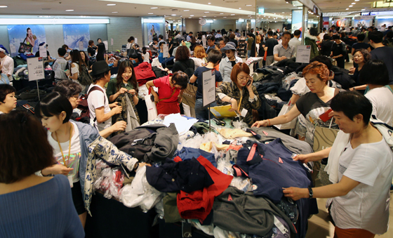 Shoppers shift through sales items at a Lotte Department Store(Yonhap)