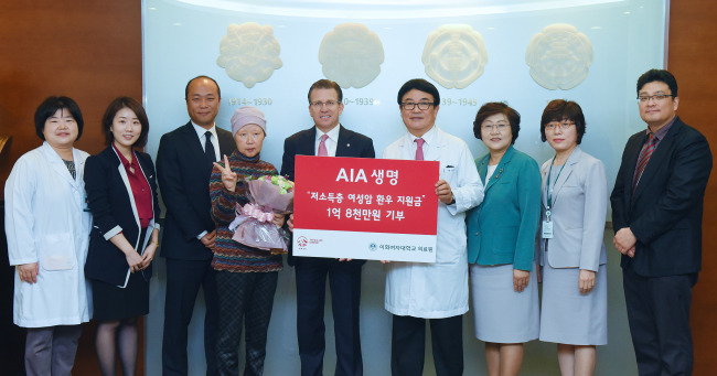 COMBAT FEMALE CANCER -- AIA Life Korea CEO Daniel L. Costello (fifth from left) poses with Ewha Womans University Cancer Center for Women chief Paik Nam-sun (sixth from left), officials and a female patient after delivering a 180 million won ($154,000) donation fund for female cancer patients. (AIA Life Korea)