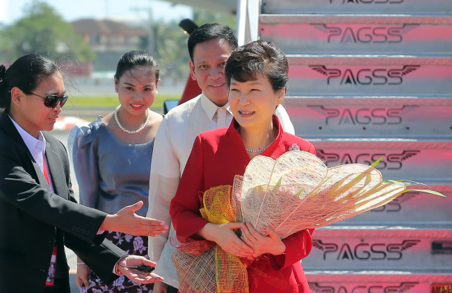 Park holds flowers presented upon her arrival in Manila on Tuesday. (Yonhap)