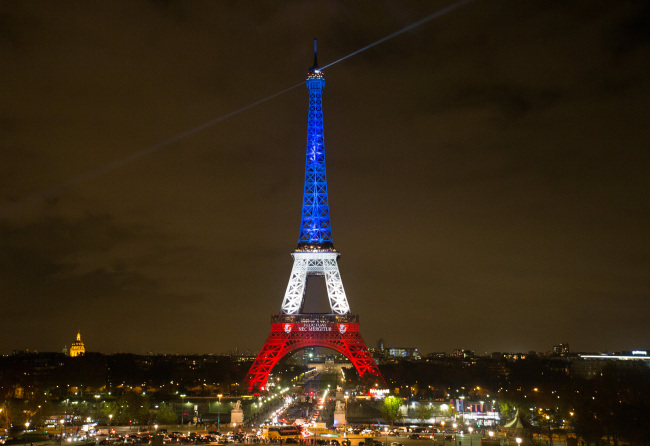 The Eiffel Tower is lit with the blue, white and red colours of the French flag in Paris, France, Nov. 16, 2015, to pay tribute to the victims of the terror attacks on Friday in the French capital. (Xinhua)