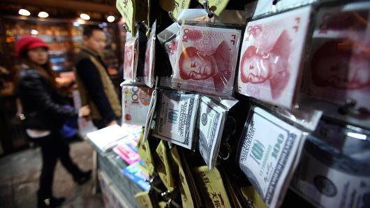 Wallets with images of the yuan and dollar banknotes are displayed at a store in Beijing. (Bloomberg)