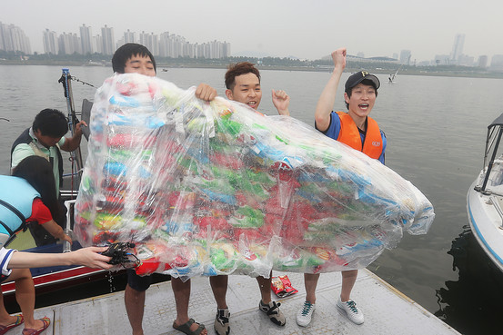 A group of Korean university students cross the Hangang River on a raft put together by connecting 160 unopened bags of potato chips on Sept. 28, 2014. (Yonhap)