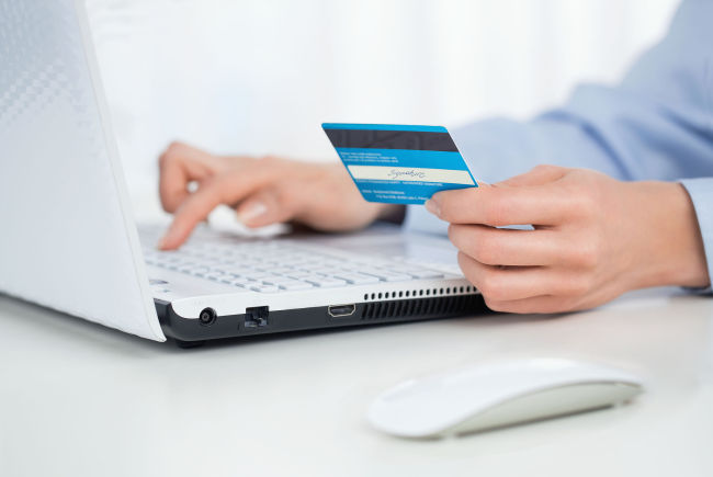 A man makes an online payment via an international credit card. (123rf)