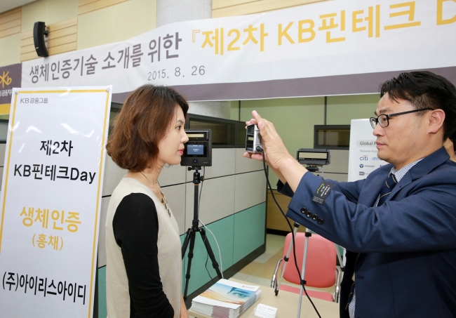 A staffer of KB Financial Group participates in a demonstration of the high-end iris-recognition technology during the second round of KB Fintech Day at the group headquarters in Yeouido, Seoul, in August. (KB Financial Group)