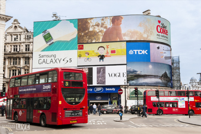 People walk past a billboard advertisement for Samsung Electronics’ Galaxy S6 at Piccadilly Circus in London. (Samsung Electronics)