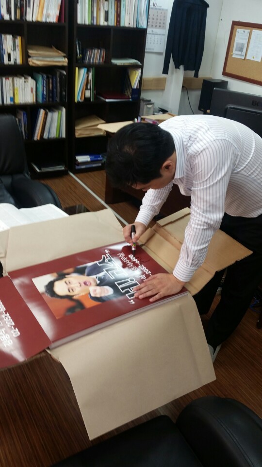 Kang Yong-suk, an outspoken television persona and partner of law firm Next Law, signs autographs on 100 of his controversial “I sue you” advertisement posters. (Kang Yong-suk’s blog)