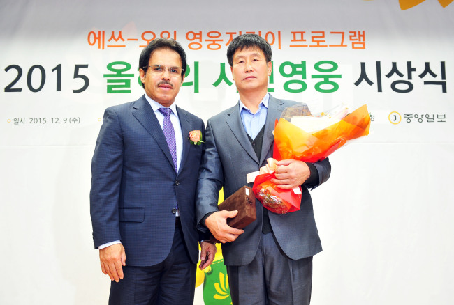 S-OIL AWARDS CIVILIAN HEROES -- S-Oil CEO Nasser al-Mahasher (left) awards a total of 140 million won ($119,000) to 20 civilian heroes in South Korea in a ceremony held in Seoul on Wednesday. Lee Seong-sun (right) was awarded the top cash prize for his courageous act of saving 10 lives in a fire that broke out in an apartment complex in Uijeongbu, Gyeonggi Province, this year. (S-Oil)