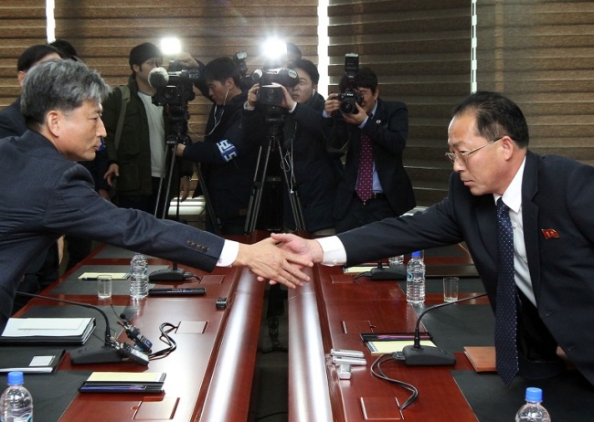 Vice Unification Minister Hwang Boo-gi (right, front) shakes hands with Jon Jong-su (left, front), a vice director of the North’s Committee for Peaceful Reunification of the Fatherland, at the start of inter-Korean high-level dialogue in the North Korean city of Gaeseong on Friday. (Joint Press Corps)