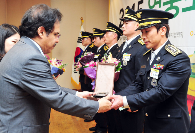 AWARD FOR FIREFIGHTERS -- S-Oil CEO Nasser Al-Mahasher (left) hands plaques and cash prizes to eight selected firefighters on Tuesday during the “2015 Hero Firefighters Award” ceremony, held at Yongsan Fire Station in Seoul. Firefighter Bae Gi-man from the Chungnam Fire Service Headquarters and seven other firefighters each received a plaque and a cash prize of 90 million won. S-Oil