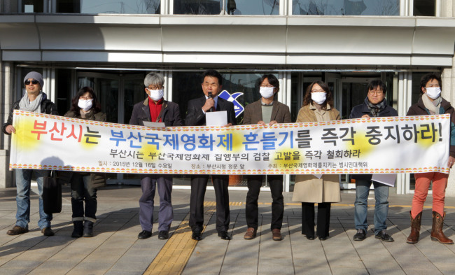 Protesters in front of the Busan Metropolitan City Hall hold up a banner urging the city government to drop charges of illegal commission fees against the Busan International Film Festival’s executive committee on Wednesday. (Yonhap) 