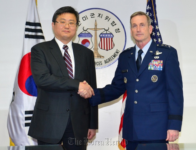 Shin Chae-hyun (left) , director-general for the Foreign Ministry`s North American affairs bureau, and his counterpart was Lt. Gen. Terrence O’Shaughnessy, deputy commander of the U.S. Forces Korea, shake hands at a meeting on Thursday at Yongsan Garrison of the Korea-U.S. Status of Forces Agreement Joint Committee. (Yonhap)