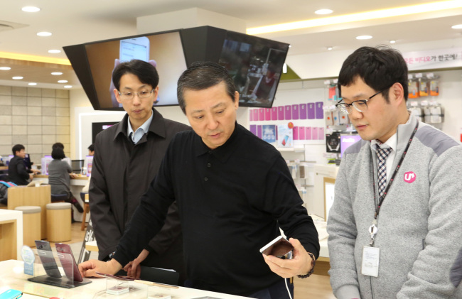 LG Uplus CEO Kwon Young-soo checks out displayed phones at a retail shop in Seoul on Wednesday. LG Uplus