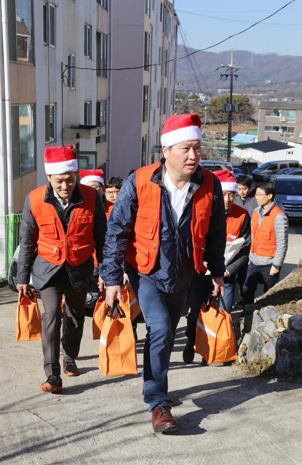 YEAR-END CHARITY — SK Group chairman Chey Tae-won and group executives deliver meal boxes to underprivileged children in Icheon, Gyeonggi Province, Friday. (SK Group)