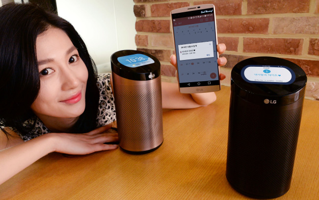 A models poses with SmartThinQ Hub, a cylinder-shaped gadget that collects the data of smart home appliances and shows them on the built-in display or users‘ smartphones. (LGE)