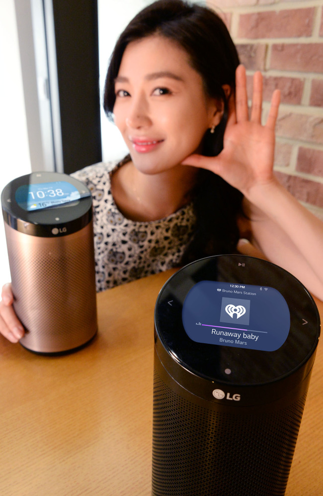 A models poses with SmartThinQ Hub, a cylinder-shaped gadget that collects the data of smart home appliances and shows them on the built-in display or users‘ smartphones. (LGE)