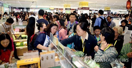 Travelers purchase duty free products at a duty free shop in Jeju International Airport. (Yonhap)
