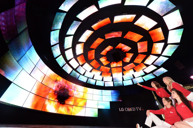 Models pose at the exhibition space of LG Electronics, featuring 112 OLED TVs to display stars in the sky, at the International CES trade show which kicks off Wednesday. (LGE)