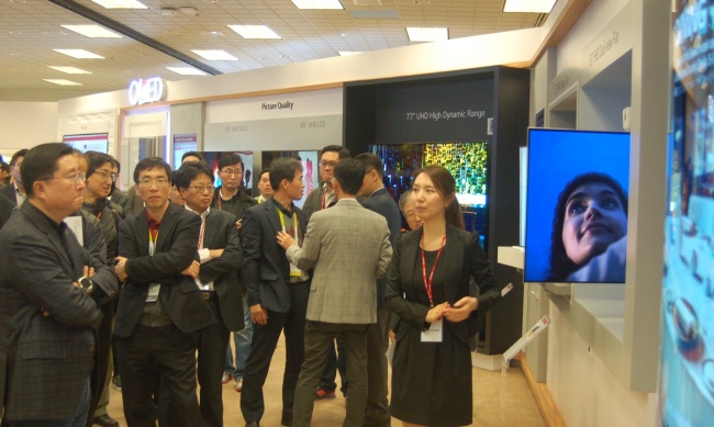 LG PREPS FOR 2016 CES -- LG Display CEO Han Sang-beom (left) pays a visit to the firm’s exhibition booth at the 2016 International CES trade show to be held from Wednesday to Saturday in Las Vegas. At the booth, the display-maker will showcase 55-inch double-sided displays, a 139-inch commercial display made of 8 organic light-emitting diode displays, and high-end OLED TVs with their sizes ranging from 65 inch to 77 inch. (LGD)