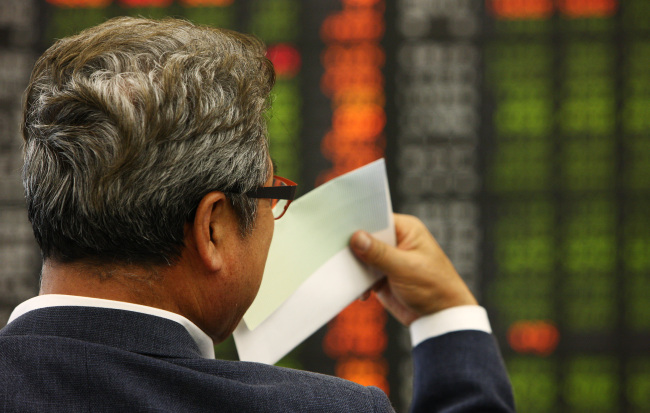 A man looks at a monitor displaying stock prices at the Daishin Securities headquarters in Seoul. (Bloomberg)