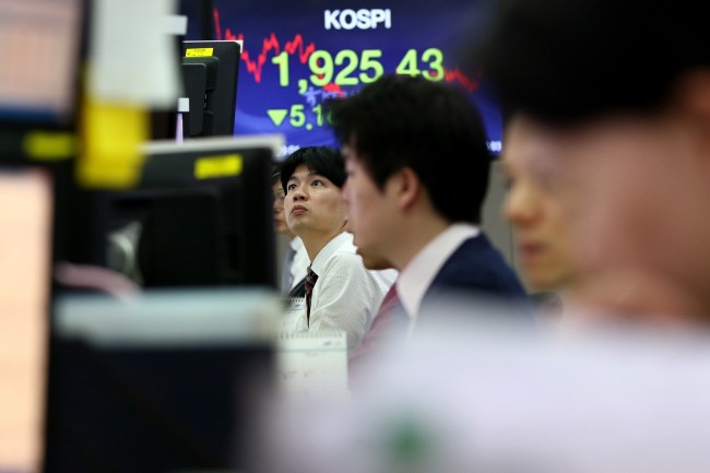 Foreign currency dealers work in front of a monitor displaying the Korea Composite Stock Price Index in a dealing room of KEB Hana Bank in Seoul. (Bloomberg)