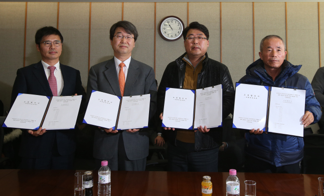 (From left)Baek Soo-hyun, a senior vice president of Samsung Electronics, Kim Ji-hyeong, head of the mediation body for Samsung’s leukemia dispute, Song Chang-ho, a representative of the group for leukemia victims’ families, and Hwang Sang-ki, head of advocacy group Banolim pose in Seoul Monday after the three parties reached an agreement on preventive measures for workers at the firm’s chip and display factories. Yonhap