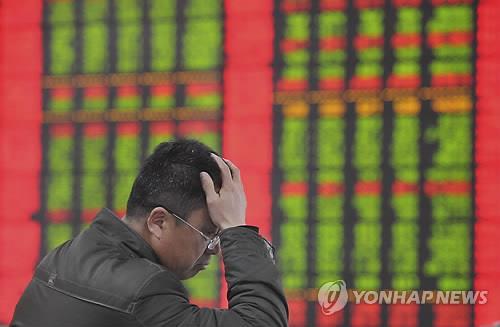 A trader holds his head in his hands at one of China’s stock exchanges. Yonhap