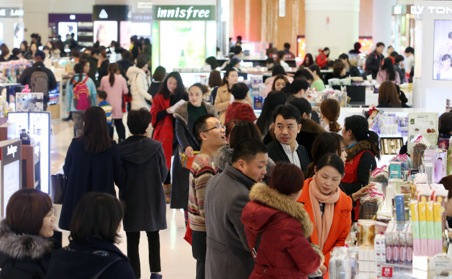 Customers cram a duty-free store located at Lotte World Tower in Jamsil, southeastern Seoul. (Yonhap)