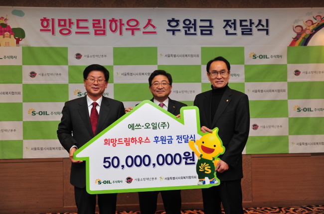 S-OIL SUPPORTS FIRE VICTIMS — S-Oil senior vice president Lee Chang-jae (center) delivers a total of 50 million won ($41,000) to Seoul Council on Social Welfare chairman Hwang Yong-kyu (right) in a ceremony held Wednesday in Seoul. The funds will be used to support underprivileged victims of fire accidents in South Korea. (S-Oil)