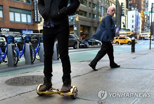 A person rides a hoverboard on the street. (Yonhap)