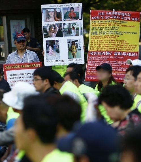 Members of an online website helping the victim of international marriage scams hold a rally calling for legal measures in Seoul in September 2013. Yonhap