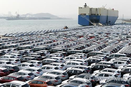 Passenger cars await shipment at a South Korean port. (Yonhap)