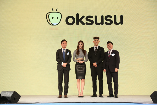 Youn Seog-am, the head of SK Broadband‘s media business unit, fitness model Yoo Seung-ok, singer Ok Taec-yeon and Kim Jong-won, chief of SK Telecom’s media business unit pose at the launch event of mobile media platform Oksusu in Seoul on Tuesday. (SKB)