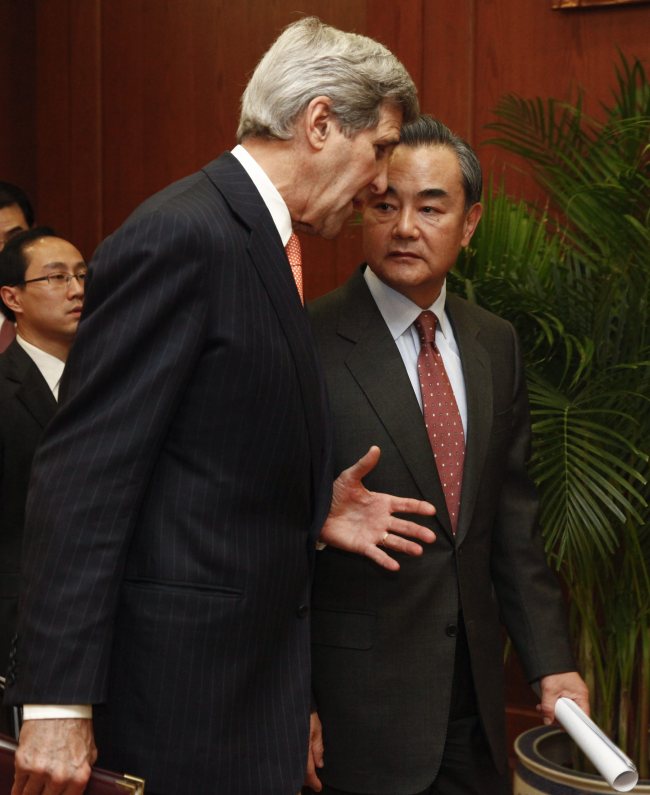 U.S. Secretary of State John Kerry (left) and Chinese Foreign Minister Wang Yi (right) talk to each other before a joint press conference at the Chinese foreign ministry in Beijing, China, on Wednesday. The two officials held talks to boost bilateral ties and discuss issues on the nuclear program of North Korea. EPA-Yonhap