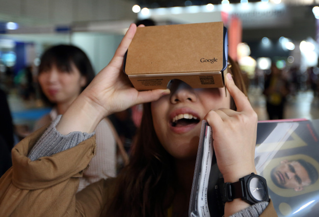 An attendee at the Tokye Game Show held in Japan last year tries the Google Cardboard goggles. (Bloomberg)