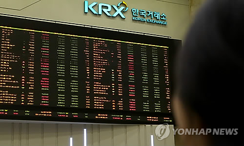 An investor watches an electronic board displaying South Korean share prices at the Korea Exchange in Yeouido, Seoul. (Yonhap)